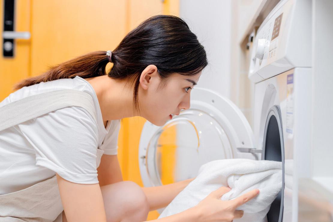 手持挂烫机抚平皱巴巴的衣物,洗完贴身衣物海绵皱巴巴的