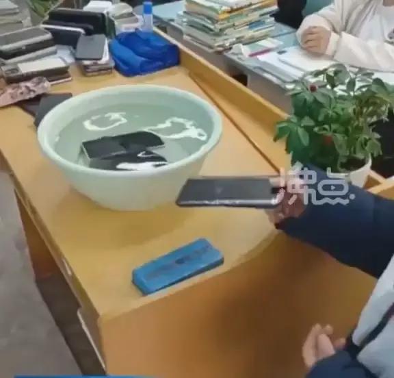老师让学生上交手机放水盆,学校回应上交手机泡水里原视频