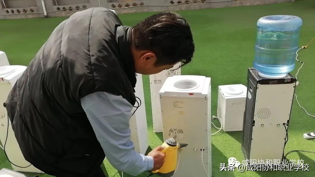 【校园安全】咸阳协和职业学校对全校的饮水机进行专业清洗