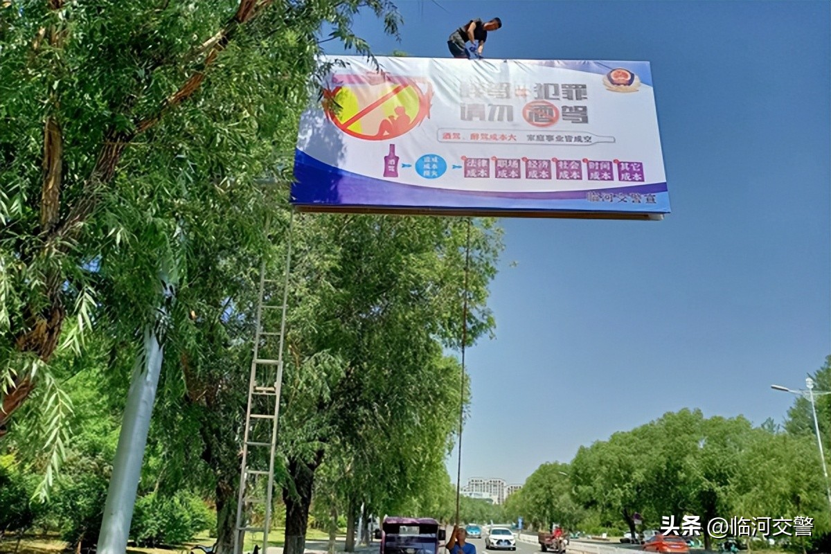 在小区宣传栏张贴交通安全警示牌,创城公益广告营造浓厚氛围